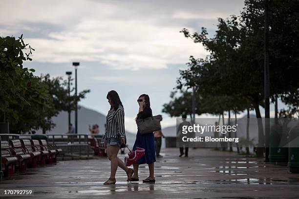 Two women walk on a waterfront promenade at Repulse Bay beach in Hong Kong, China, on Sunday, June 16, 2013. A shortage of housing, low mortgage...