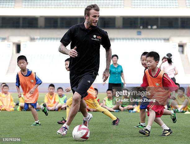 David Beckham plays football with children at Nanjing Olympic Sports Center on June 18, 2013 in Nanjing, Jiangsu Province of China.