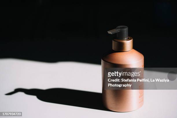 soap dispenser casting shadow on white background - shampoo bottle white background stock-fotos und bilder