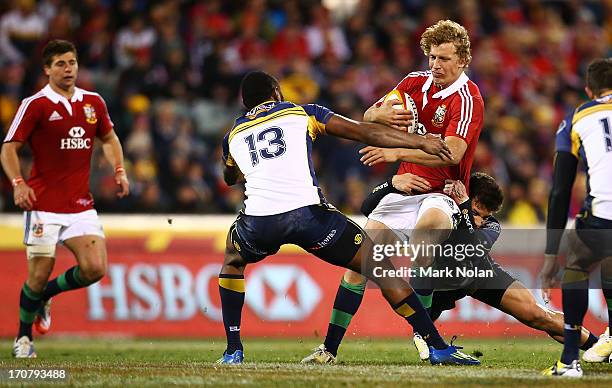 Billy Twelvetrees of the Lions is put under pressure by the Brumbies defence during the International tour match between the ACT Brumbies and the...