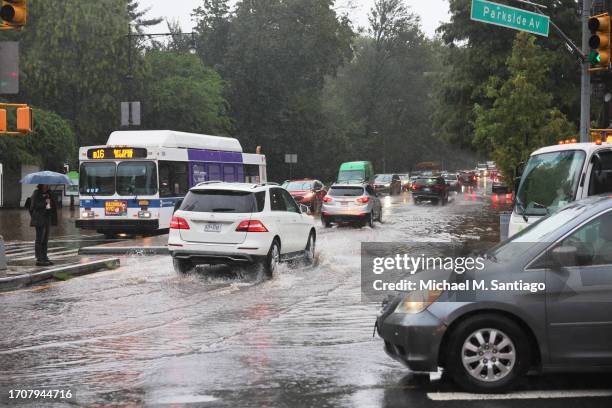 Cars drive through slight flooding on Ocean Avenue amid heavy rain on September 29, 2023 in the Flatbush neighborhood of Brooklyn borough New York...