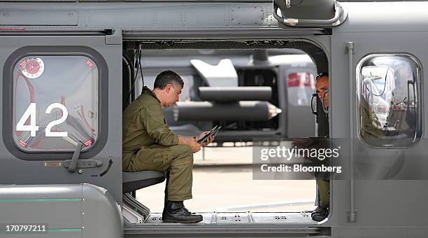 Aircrew members use electronic personal devices as they sit inside an AW189 helicopter, manufactured by Agusta Westland, a unit of Finmeccannica SpA,...