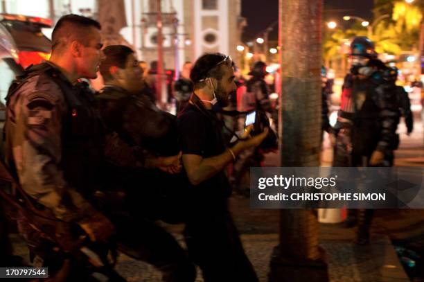 Blogger is arrested by anti-riot military unit soldiers next to the legislative parliament during clashes in Rio de Janeiro's downtown on june 17,...