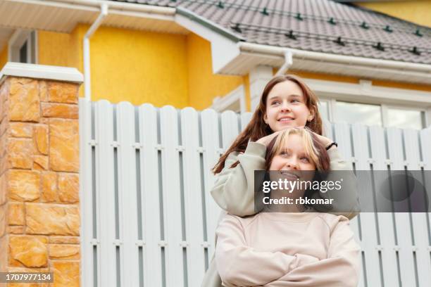two female friends relaxing in the yard of a townhouse - carefree weekend - resting head on shoulder stock pictures, royalty-free photos & images