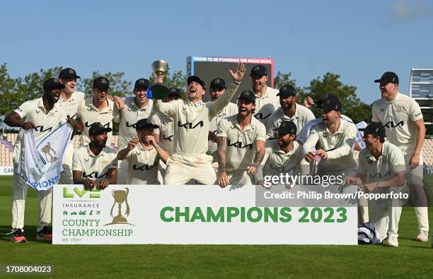 Rory Burns of Surrey lifts the County Championship trophy with team-mates after the LV= Insurance County Championship Division 1 match between...