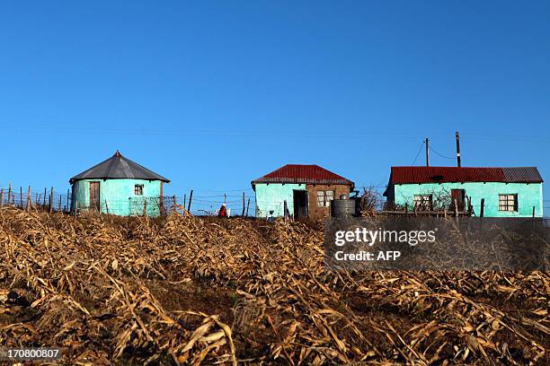 Woman walks between two houses on June 11, 2013 in Qunu, a village outside the town of Mthatha in the Eastern Cape, where former South African...