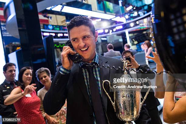 Golfer Justin Rose poses for a photo with a phone on the floor of the New York Stock Exchange after joining the cast of CNBC's "Squawk on the Street"...