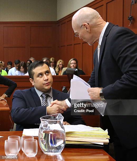 George Zimmerman greets one of his attorneys, Don West, in Seminole circuit court on the 7th day of his trial June 18, 2013 in Sanford, Florida....