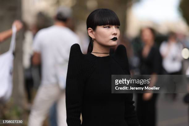 Fashion Week guest is seen wearing a black knitted long sleeve dress with pointed shoulders from Rick Owens before the Rick Owens Show Womenswear...