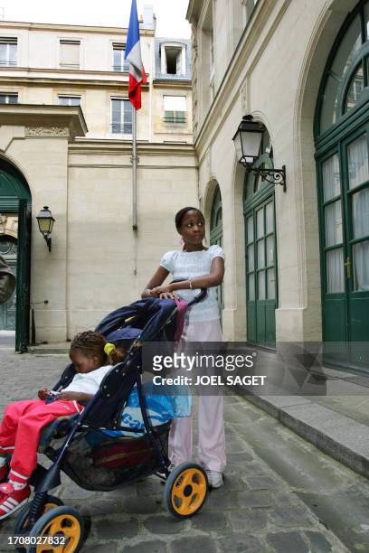 Les enfants d'une personne mal logée posent, le 01 septembre 2005 à Paris, lors d'une action symbolique de l'association Droit au logement dans un...