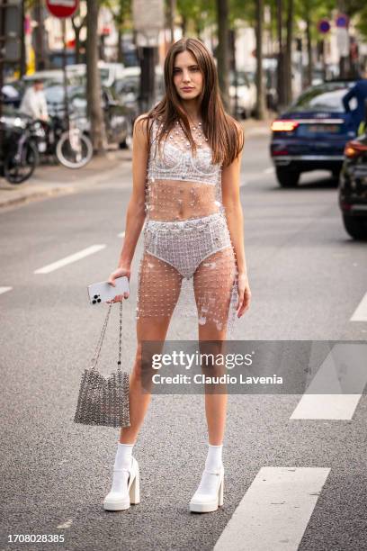 Macarena Achaga wears a white tweed crop top with matching culotte, clear sequins mini dress, white socks, white platform heels and silver metal bag,...