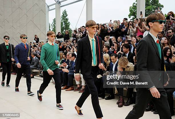 Guests including Carla Sozzani, Mohammed Al Turki and Jamie Campbell Bower sit in the front row at Burberry Menswear Spring/Summer 2014 at Kensington...