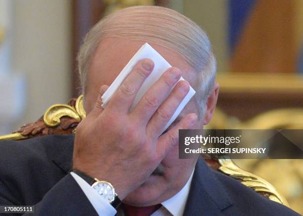 Belarussian President Alexander Lukashenko wipes his brow on June 18, 2013 during his meeting with his Ukrainian counterpart in Kiev. Lukashenko...