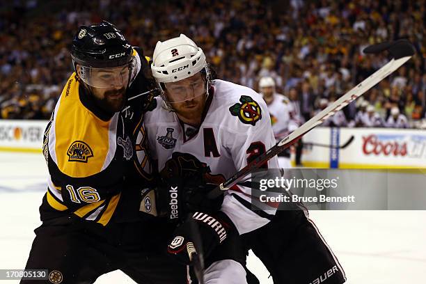 Kaspars Daugavins of the Boston Bruins checks Duncan Keith of the Chicago Blackhawks in Game Three of the 2013 NHL Stanley Cup Final at TD Garden on...