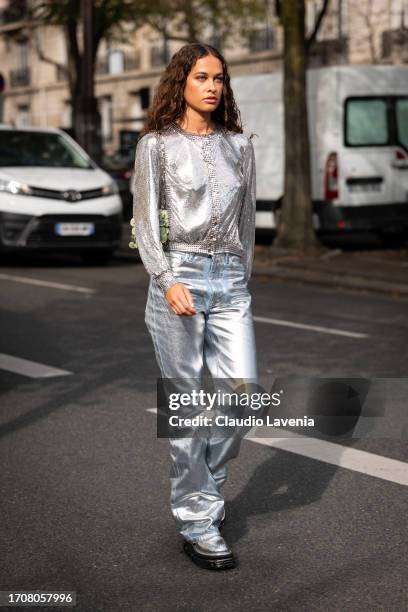 Sarah Lysander wears a silver sequins long sleeves top, silver jeans, silver boots and green metal bag, outside Rabanne, during the Womenswear...