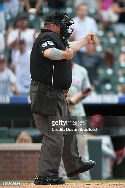 Umpire Wally Bell signals a strike out to end the game during a game between the Colorado Rockies and the Philadelphia Phillies at Coors Field on...