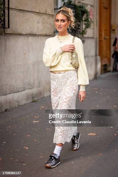 Emili Sindlev wears a yellow sweater, cream lace midi skirt, silver sneakers and yellow bag with silver metal details, outside Rabanne, during the...