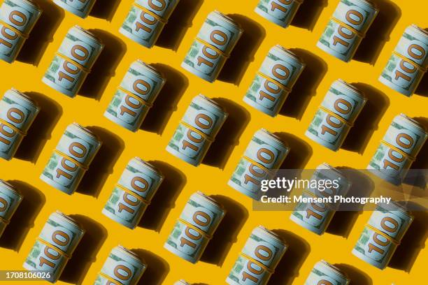 abstract roll of american 100 usd dollars banknotes on the yellow background - canadian one hundred dollar bill 個照片及圖片檔