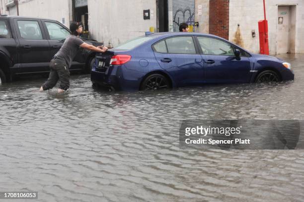 Car is pushed through flooded streets in the Red Hook neighborhood on September 29, 2023 in the Brooklyn borough of New York City. Much of the...