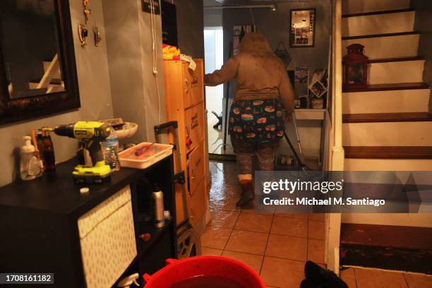 Person walks along their flooded basement on E 10th Street amid a coastal storm on September 29, 2023 in the Flatbush neighborhood of Brooklyn...