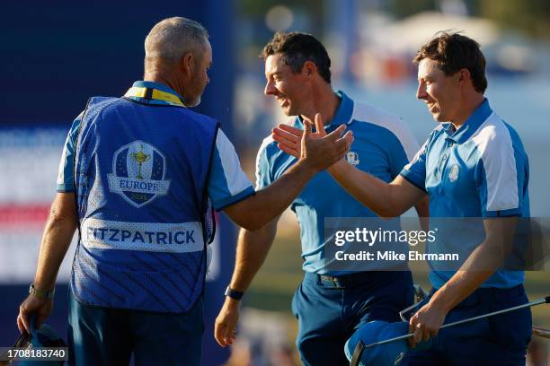 Matt Fitzpatrick of Team Europe and caddie, Billy Foster celebrate with teammate Rory McIlroy on the 15th green during the Friday afternoon fourball...