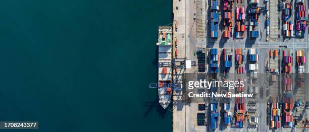 aerial view of containerized cargo handling and freight transportation. industrial import-export port prepare to load containers. - containers harbour stock pictures, royalty-free photos & images