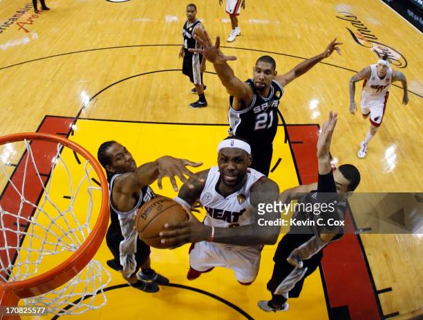 LeBron James of the Miami Heat looks to go up for a shot against Kawhi Leonard, Tim Duncan and Danny Green of the San Antonio Spurs in the first half...