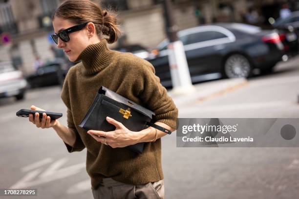 Guest wears an olive green sweater, black Ray Ban sunglasses and black Hermes bag, outside Chloe, during the Womenswear Spring/Summer 2024 as part of...
