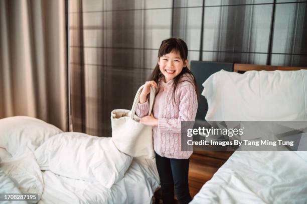 lovely cheerful girl packing her bag and getting ready to check out her hotel room after the family vacation - retail equipment stock pictures, royalty-free photos & images