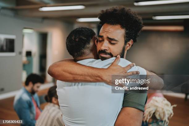 people hugging each other in emotional support group - krama bildbanksfoton och bilder