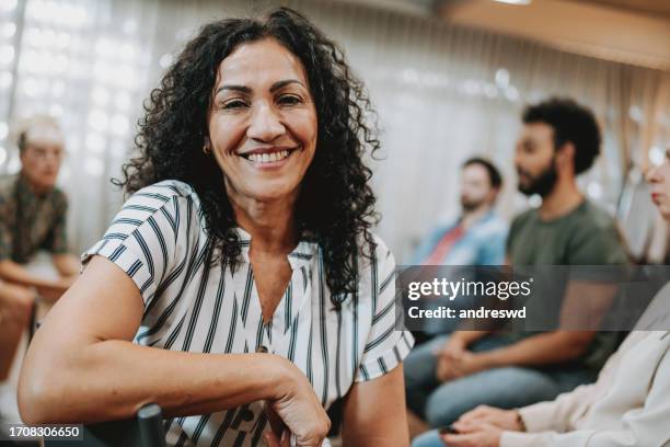 retrato de una mujer sonriente en terapia de grupo - mejora personal fotografías e imágenes de stock