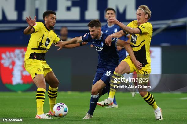 Felix Nmecha and Julian Brandt of Borussia Dortmund battles for the ball with Anton Stach of TSG Hoffenheim during the Bundesliga match between TSG...