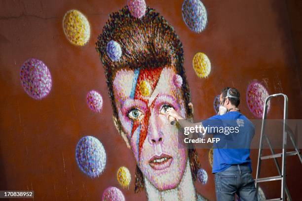 Australian street artist James Cochran, also known as Jimmy C, puts the finishing touches on a large 3D wall portrait of British musician David Bowie...