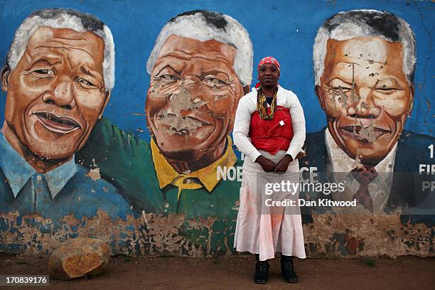 Nokuthula Mbonde poses for a portrait by a mural of Nelson Mandela in Soweto on June 14, 2013 in Johannesburg, South Africa. Speaking of Nelson...