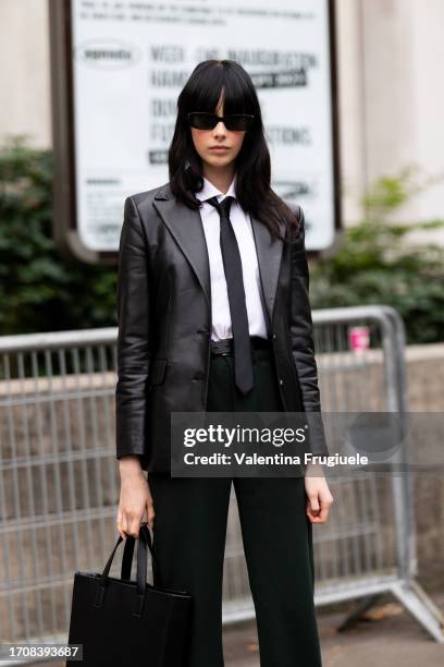 Guest is seen wearing dark green trousers, a black leather bag, a white shirt, a black tie, a black leather blazer and black sunglasses outside the...