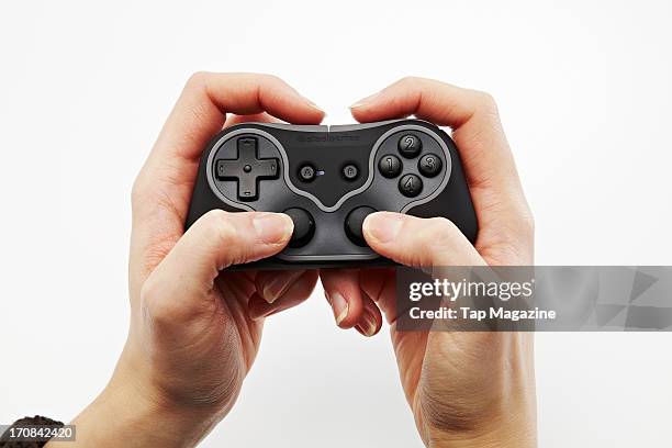 Close-up of a woman's hands holding a SteelSeries Free game controller for iOS devices photographed during a studio shoot for Tap Magazine, November...