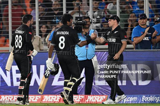 New Zealand's captain Tom Latham greets Rachin Ravindra and Devon Conway after winning the 2023 ICC men's cricket World Cup one-day international...