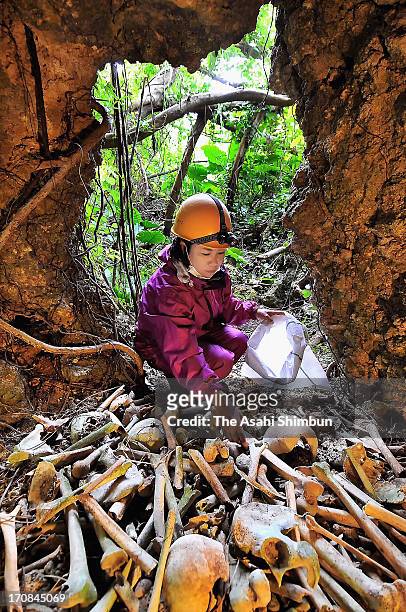 Maiko Masaki recovers the remains of victims of the battle of Okinawa at a cave on February 6, 2013 in Itoman, Okinawa, Japan. During three-month...