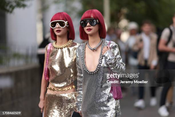 Aya Suzuki is seen wearin a silver sequin dress with silver balls and a silver necklace, as well as black sunglasses. Ami Suzuki wears a gold top...