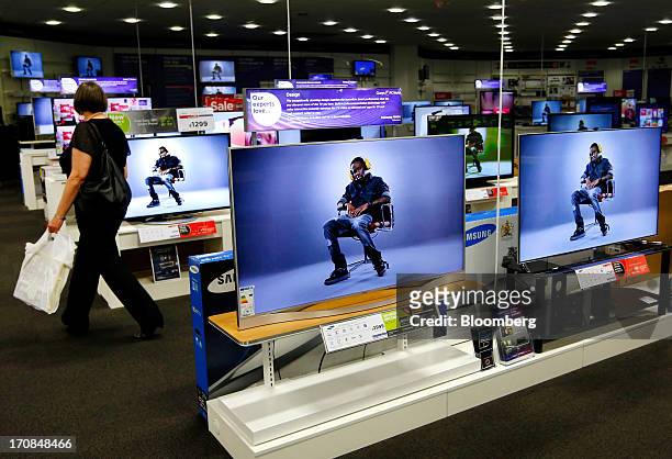 Customer browses a display of flat screen televisions inside a Currys and PC World 2 in 1 store, operated by Dixons Retail Plc, in Manchester, U.K.,...