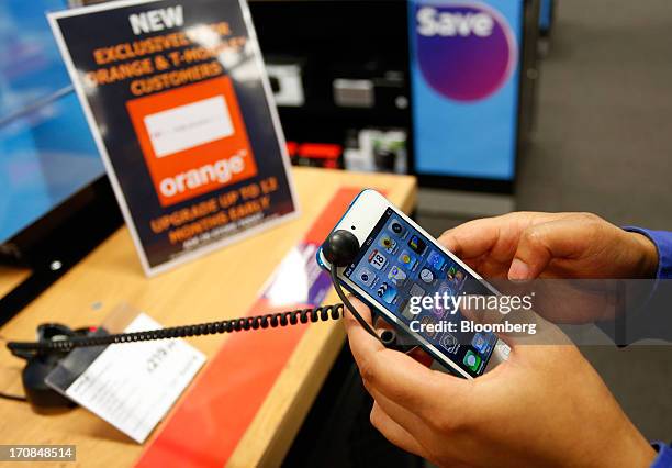 Phones 4u Ltd. Employee demonstrates an Apple Inc. IPod touch inside a Currys and PC World 2 in 1 store, operated by Dixons Retail Plc, in...