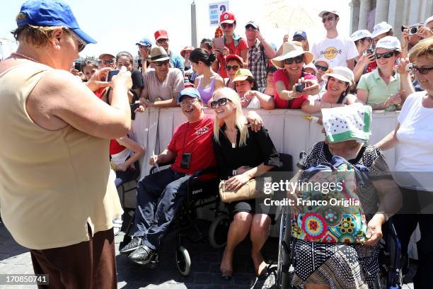 Former Argentinian top model Valeria Mazza poses with handicapped persons as he leaves St. Peter's square at the end of the Pope Francis' weekly...