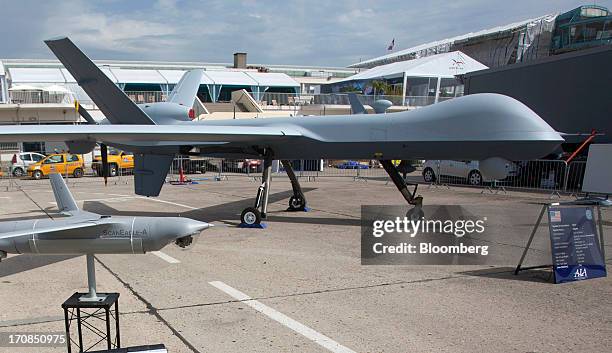 Boeing Co. ScanEagle unmanned aerial vehicle , left, sits on display near a PREDATOR B, or MQ-9 Reaper unmanned air vehicle or drone, manufactured by...