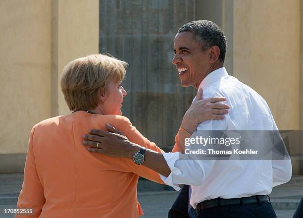 German Chancellor Angela Merkel and U.S. President Barack Obama hug after Obama gave a speech in front of Berlin's landmark the Brandenburg Gate near...