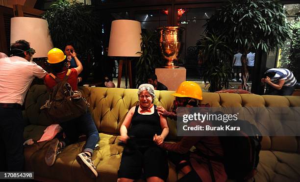 Protesters take shelter in the Divan Hotel during clashes with Turkish riot police firing tear gas on June 15, 2013 Istanbul, Turkey. Protests which...