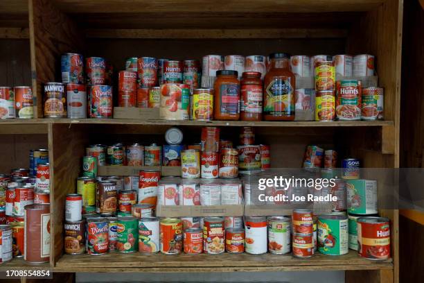 Cans of food for those in need sit on a shelf at the LifeNet4Families community-based food pantry on September 29, 2023 in Fort Lauderdale, Florida....