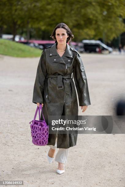 Astrid Boutrot wears purple bag Loewe, green belted leather coat, creme white pants, pointed heels outside Loewe during the Womenswear Spring/Summer...