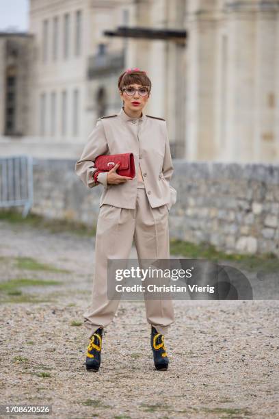 Salome Chaboki wears wool gabardine jacket Akris, tapered wool gabardine pants with pleats Akris, boots Sheme, glasses Ralph Vassen, shagreen bag...