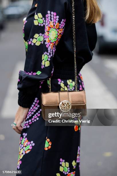 Maria Rosaria Rizzo wears black button shirt, pants with graphic print, metallic bag outside Leonard Paris during the Womenswear Spring/Summer 2024...