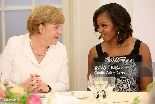German Chancellor Angela Merkel speaks to U.S. First Lady Michelle Obama at a dinner at the Orangerie at Schloss Charlottenburg palace on June 19,...